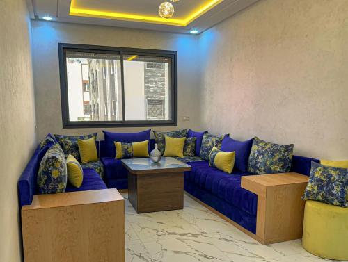 a living room with a blue couch with yellow pillows at The gray pearl in Agadir