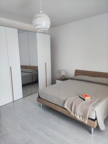 a bedroom with a bed with a book on it at A casa di Nonna Maria in Grottole