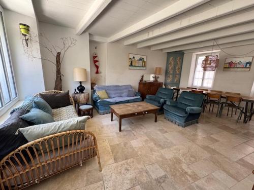 un salon avec un canapé, des chaises et une table dans l'établissement La Maison de la Tribu - Ile de Ré - La Flotte, à La Flotte