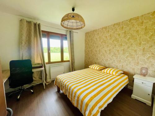 une chambre avec un lit, un bureau et une chaise dans l'établissement Grande maison avec jardin, à Guérard