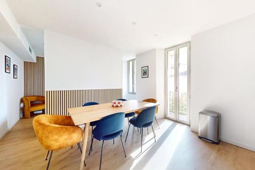 une salle à manger avec une table en bois et des chaises bleues dans l'établissement App refait neuf 3P Clim proche plage palais festival, à Cannes