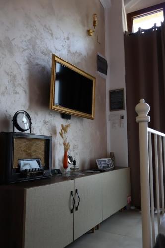 a living room with a television on a wall at Riverside Apartment in Bitola