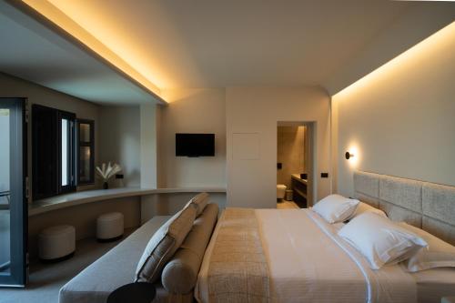 a bedroom with a large bed and a tv at Black Diamond Suites in Akrotiri