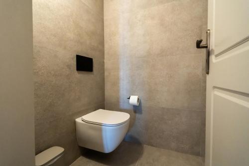 a bathroom with a toilet and a toilet paper dispenser at Black Diamond Suites in Akrotiri