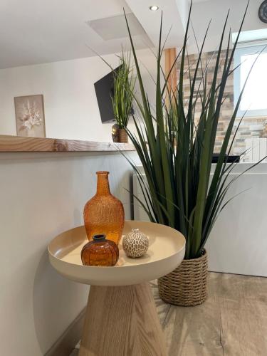 une table avec un vase et une plante sur elle dans l'établissement Le Temps d une Escapade, à Saint-Savinien