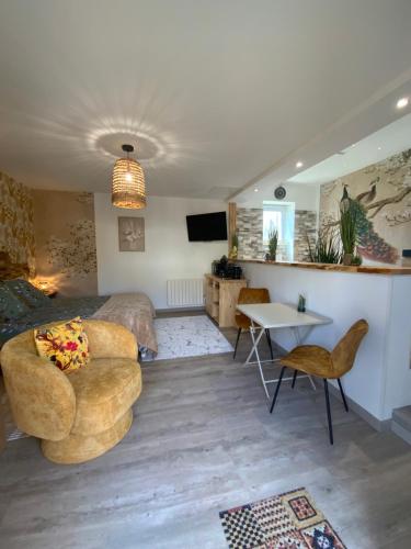 une chambre avec un lit, une table et des chaises dans l'établissement Le Temps d une Escapade, à Saint-Savinien