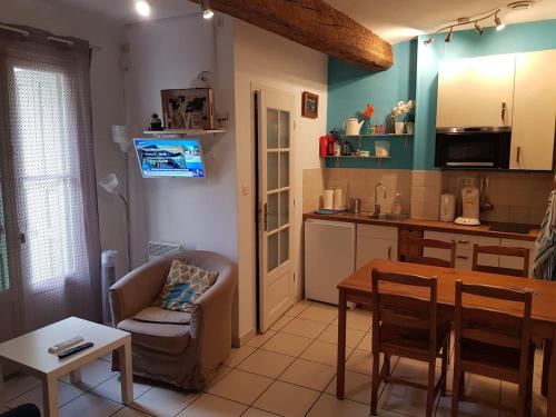 una cucina con un tavolo e una sala da pranzo di Maison de pêcheurs 50 m de la Plage d'Avall a Collioure