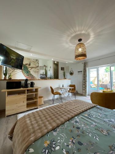 - une chambre avec un grand lit, une table et des chaises dans l'établissement Le Temps d une Escapade, à Saint-Savinien