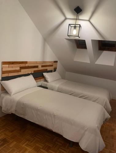 two beds in a attic room with a light at Apartamento en Mansilla in Mansilla de las Mulas