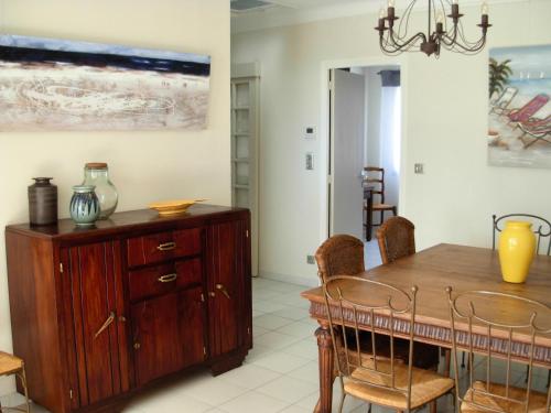 d'une salle à manger avec une table et une armoire en bois. dans l'établissement Villa Orane, à Argelès-sur-Mer
