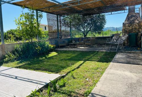 a garden with a patio with a table and chairs at Holiday Home Sea & River Pearl in Komin