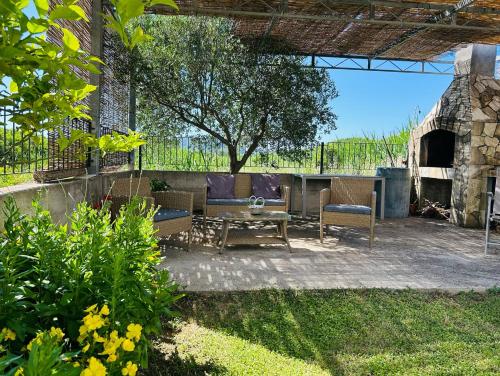 a patio with a table and chairs and a tree at Holiday Home Sea & River Pearl in Komin