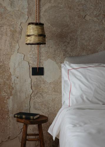 a bedroom with a bed and a table with a lamp at Convento Francescano Experience Hotel Cilento in Cuccaro Vetere