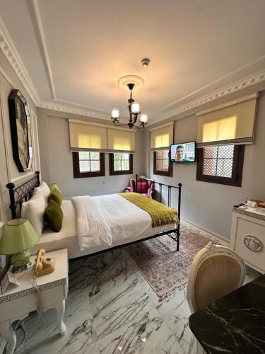 a bedroom with a large bed with a chandelier at Villa Ephesus Hotel in Kusadası