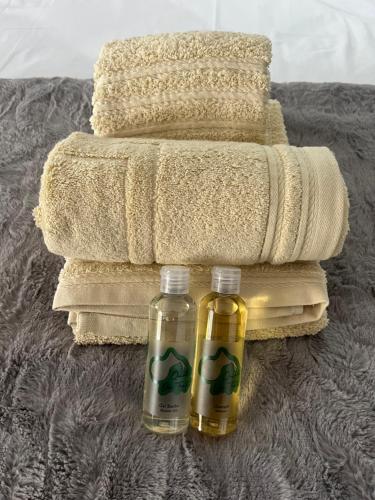 zwei Flaschen Shampoo stehen auf einem Bett mit Handtüchern in der Unterkunft Quinta da Fonte de Grandola in Grândola