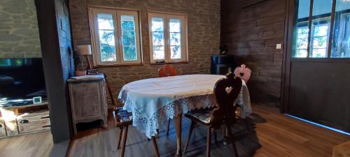 une pièce avec une table et deux chaises et des fenêtres dans l'établissement Chalet aux 2 sapins, à Saint-Pierre-Bois