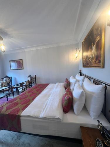 a bedroom with a bed with white sheets and pillows at Villa Ephesus Hotel in Kusadası