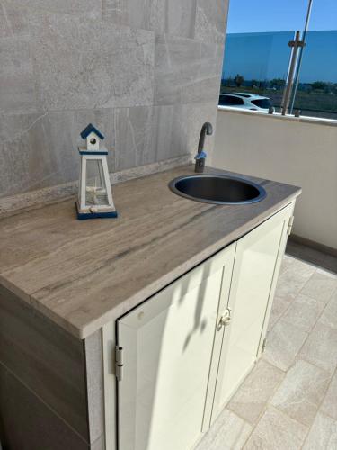 a kitchen counter with a sink and a counter at Hellen House Monopoli in Monopoli