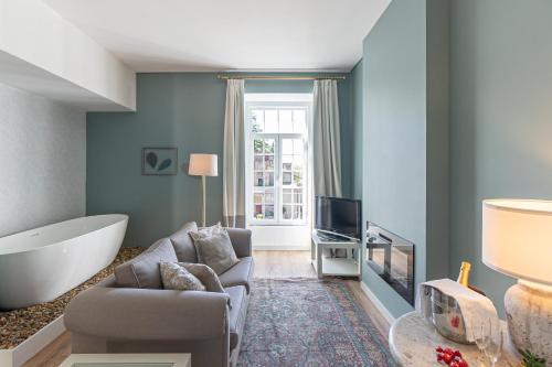 a living room with a tub and a couch and a tv at Águas do Gerês - Hotel, Termas & Spa in Geres