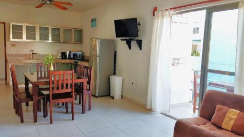 une cuisine et une salle à manger avec une table et un réfrigérateur dans l'établissement Arrecifes Suites, à Puerto Morelos