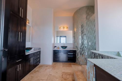 a kitchen with black cabinets and a sink at Diamante Beachfront Suites in San Pedro