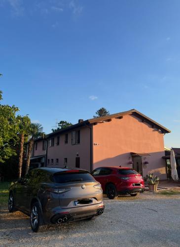two cars parked in a parking lot in front of a building at Agriturismo La Rondinella in Dozza