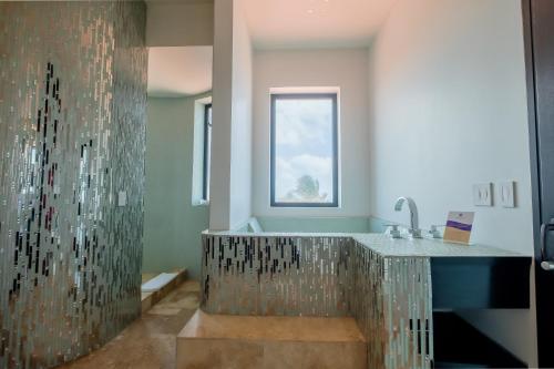 a bathroom with a shower with a glass wall at Diamante Beachfront Suites in San Pedro