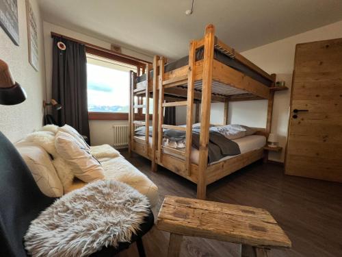ヴェルビエにあるVerbier cozy Medran ski in ski outの二段ベッド2台とソファのあるリビングルーム