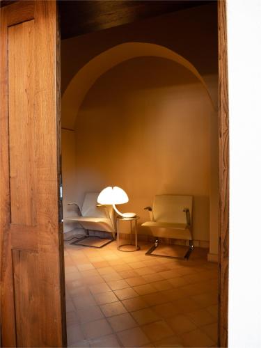 a room with two chairs and a table with a lamp at Convento Francescano Experience Hotel Cilento in Cuccaro Vetere