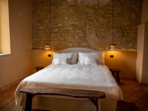 a bedroom with a large bed with white sheets and pillows at Convento Francescano Experience Hotel Cilento in Cuccaro Vetere