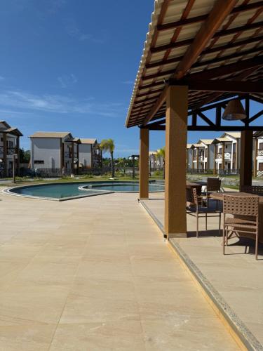 a patio with a table and chairs next to a pool at Paraíso dos Lençóis casa 08 Atins in Atins