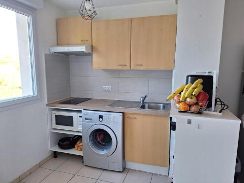 une cuisine avec une machine à laver et un évier dans l'établissement Appartement dans résidence standing piscine, tennis, à Perpignan