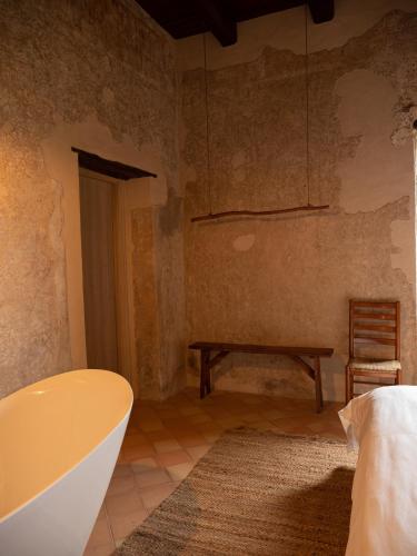 a bathroom with a tub and a table and a chair at Convento Francescano Experience Hotel Cilento in Cuccaro Vetere