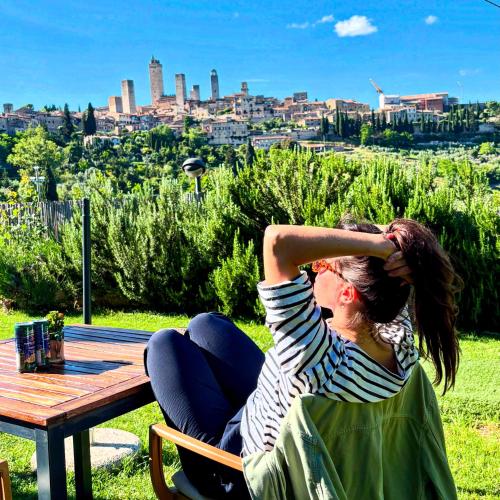 two women sitting at a picnic table with a view of a city at B&B Il Fienile San Gimignano in San Gimignano