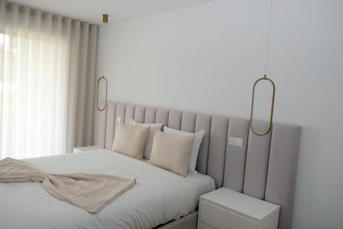 una camera bianca con un grande letto con due luci di Olive House - 4 bedrooms a Gafanha da Nazaré