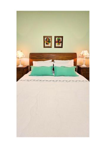 a bedroom with a white bed with two pillows at Jardim Secreto - Itaipava in Itaipava