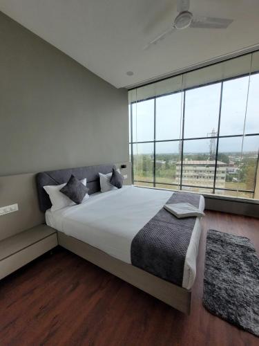 a bedroom with a large bed with a large window at Hotel Great View in Sangli