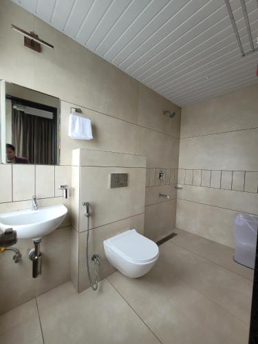a bathroom with a toilet and a sink at Hotel Great View in Sangli