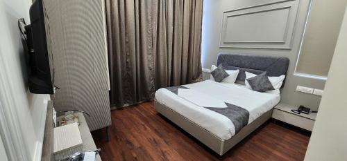 a hotel room with a bed and a television at Hotel Great View in Sangli