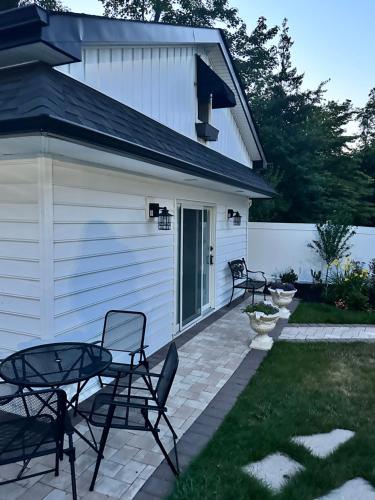a patio with two chairs and a table next to a building at The Most Desired Summer Retreat with Private Pool Just 5 Minutes from the Beach in Spring Lake