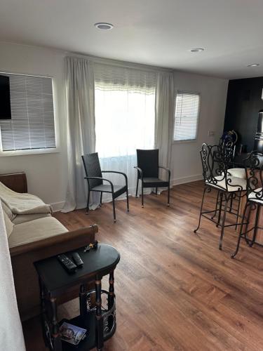 a living room with chairs and a couch and a table at The Most Desired Summer Retreat with Private Pool Just 5 Minutes from the Beach in Spring Lake