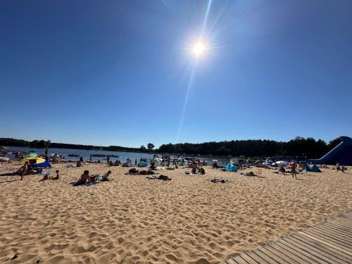 a group of people sitting on a beach at Apartament pod sosenką Sielpia Wielka in Sielpia Wielka