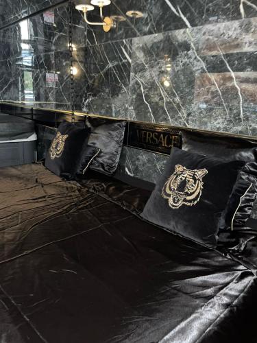 un lit noir avec des oreillers noirs dessus dans l'établissement Suite avec jacuzzi, à Montpellier