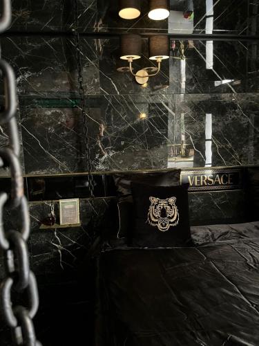 une chambre noire avec un lit avec un oreiller dessus dans l'établissement Suite avec jacuzzi, à Montpellier