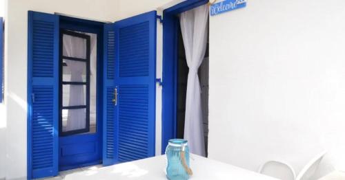 a vase sitting on a table in front of a blue door at Mikri elia beach in Lagomandra