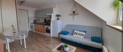 un salon avec un canapé et une table et une cuisine dans l'établissement Studio à 50 Mètres de la plage avec wifi, à Berck-sur-Mer