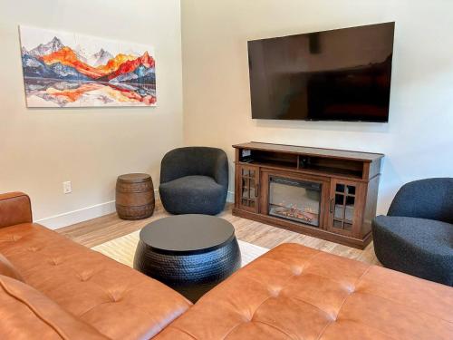 a living room with a couch and a flat screen tv at Teton Duo | Side-by-Side Homes | Hot Tubs+Walkable in Driggs