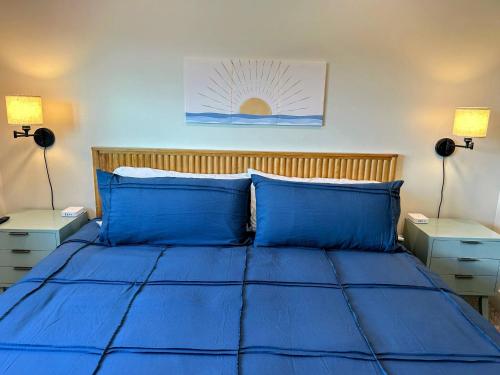 a blue bed with two blue pillows and two lamps at Teton Duo | Side-by-Side Homes | Hot Tubs+Walkable in Driggs