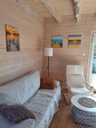 a living room with a couch and a chair at Domki letniskowe Czapli9 Domki Rewal Apartamenty in Rewal