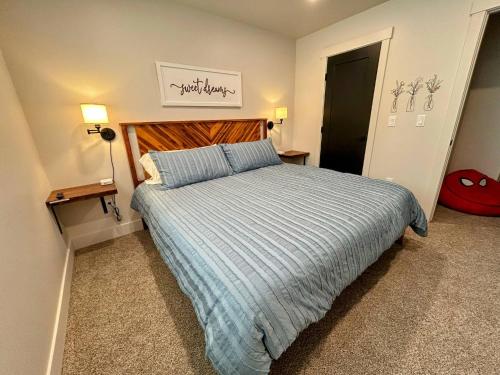 a bedroom with a large bed with a wooden headboard at Teton Duo | Side-by-Side Homes | Hot Tubs+Walkable in Driggs